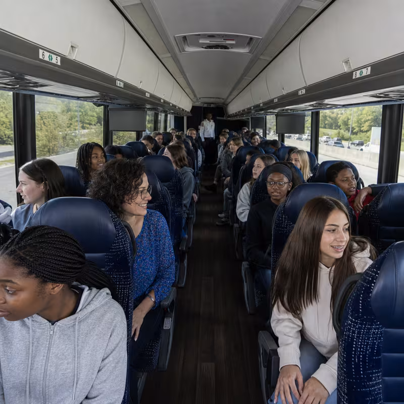 Group boarding a white charter bus for School Transportation transportation in Oklahoma City