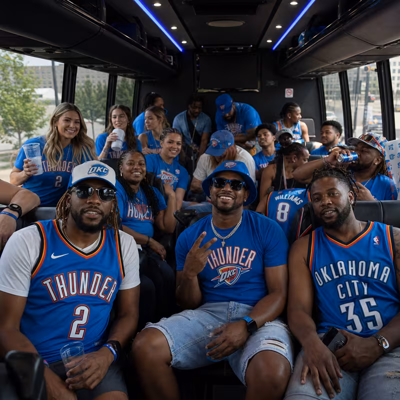 Group boarding a white charter bus for Sporting Event Transportation transportation in Oklahoma City